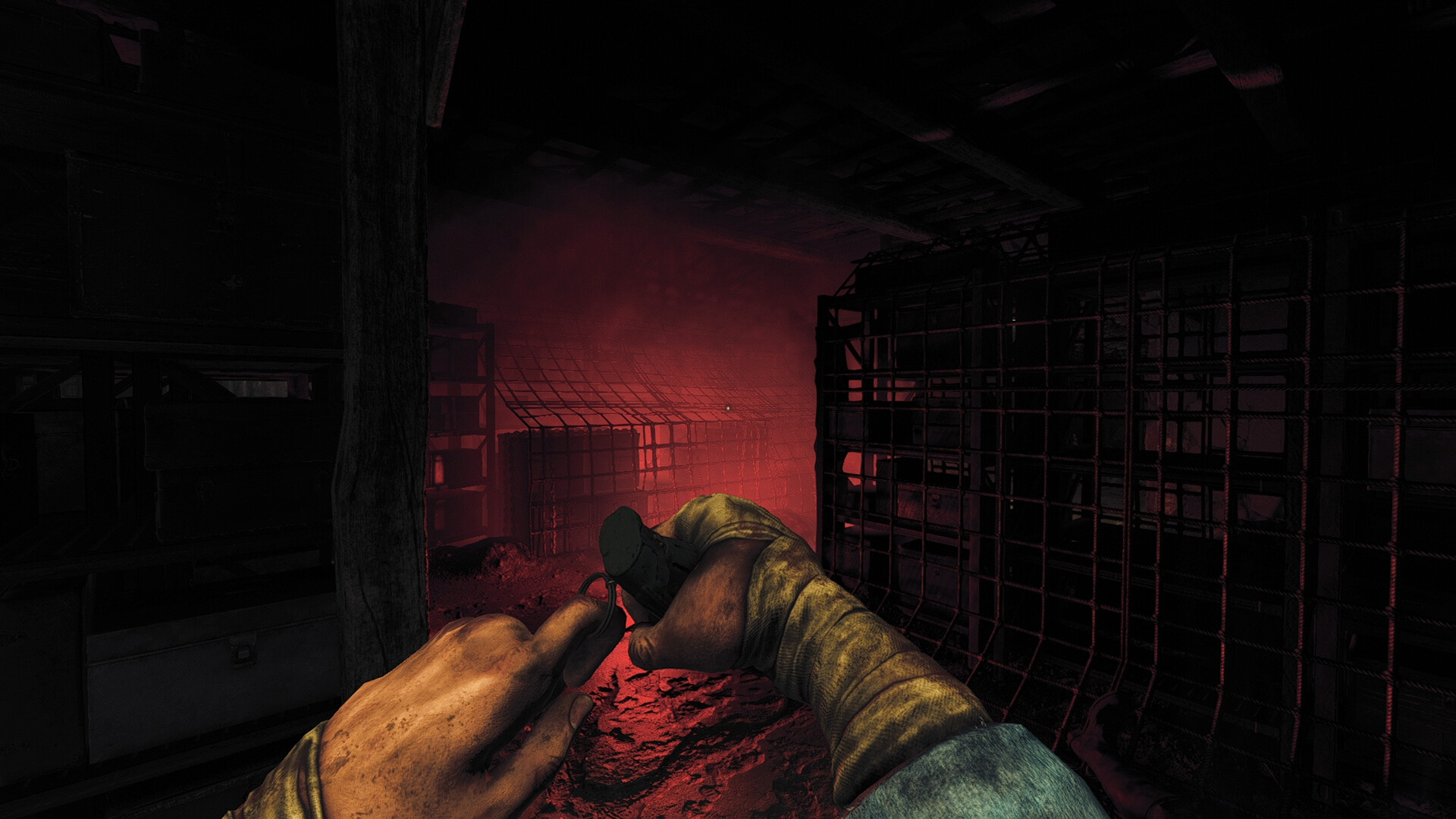 Henri cutting wire with a tool in a dark room lit in red