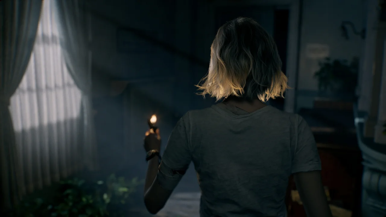 Grace holding a candle in a dark interior, viewed from behind